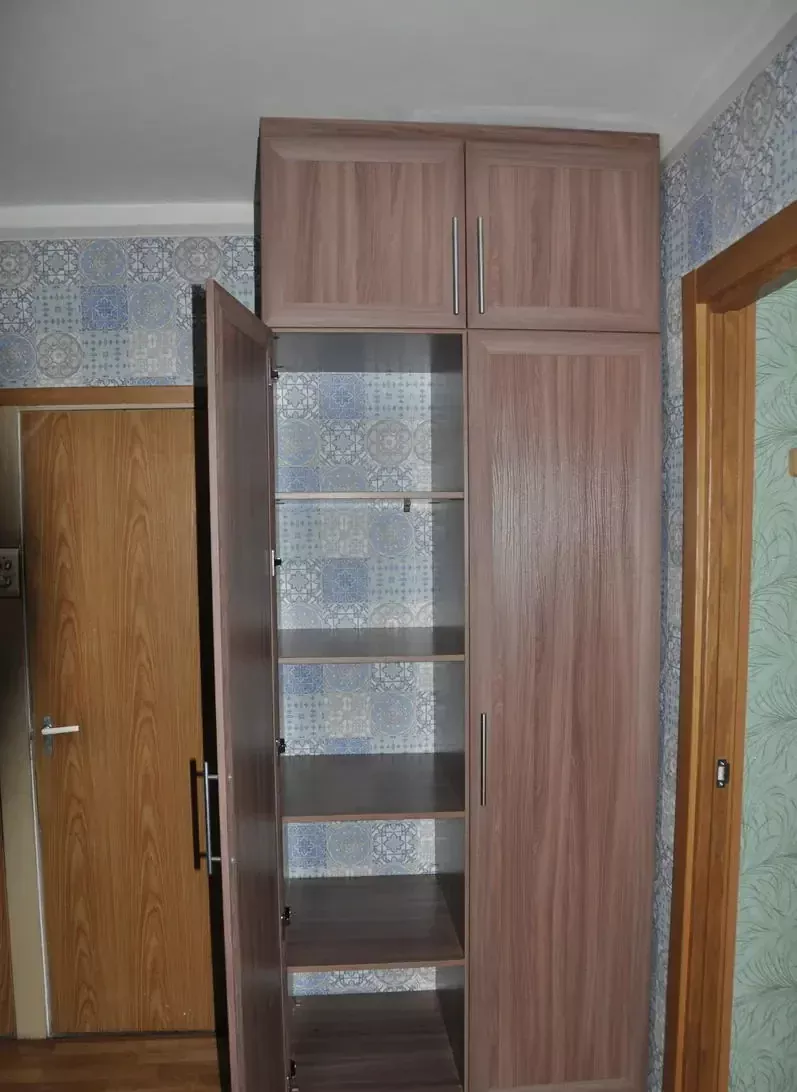 Открытая дверь распашного шкафа с полками